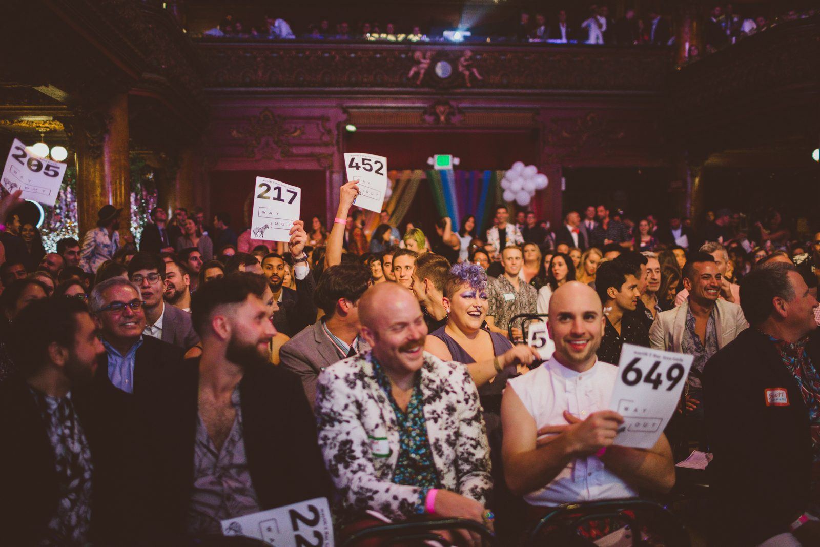 Guests raise auction paddles at the Bay Area Gayla