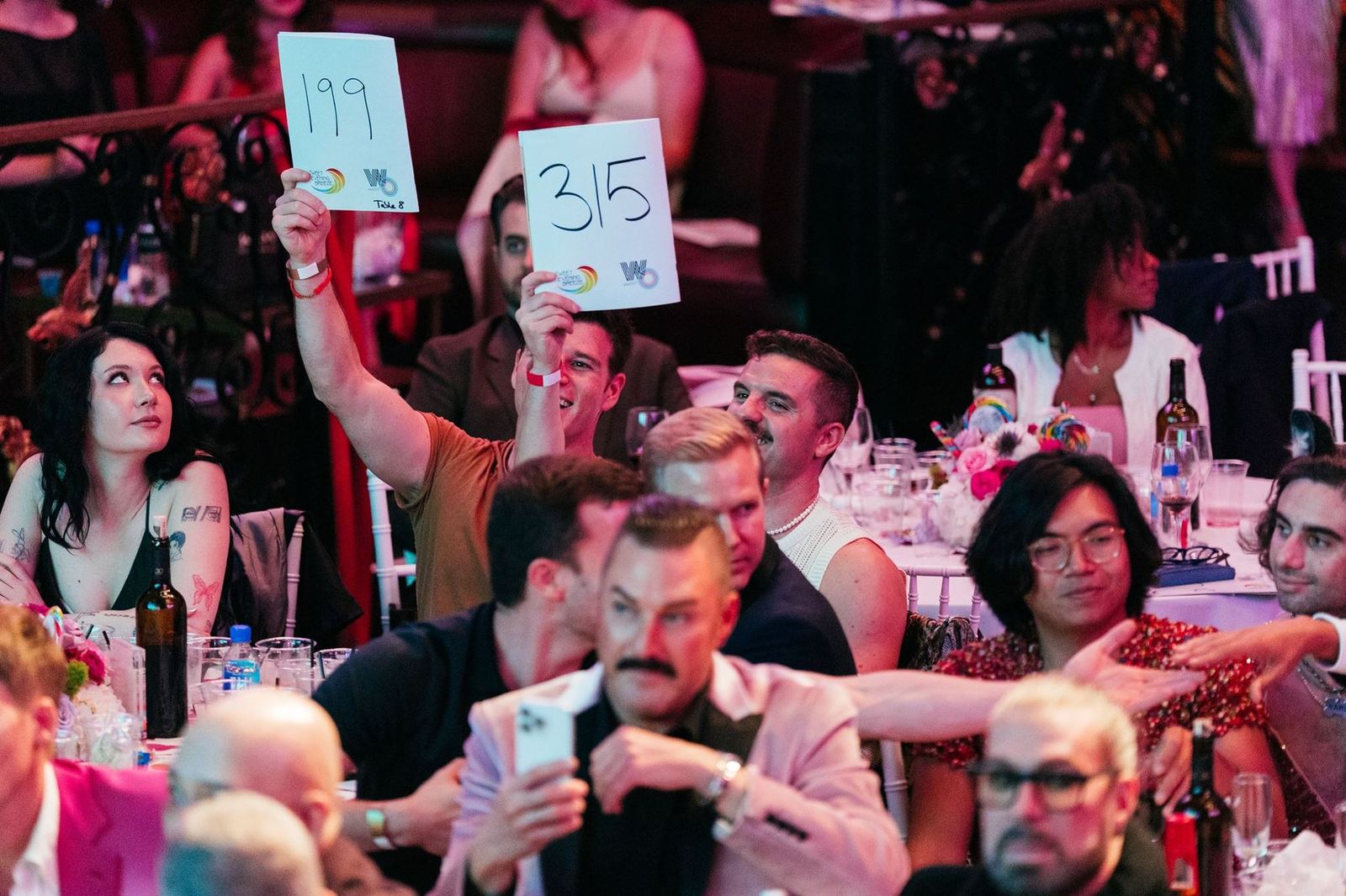 Guests raise bid paddles during the 2025 live auction