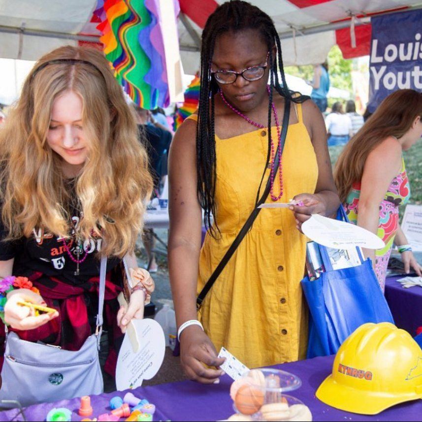Young people at a Louisville Youth Group table at a Pride event