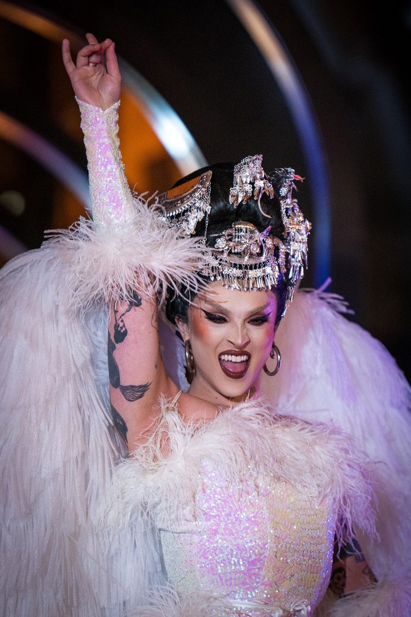A drag performer in white feathers at a wayOUT Seattle night